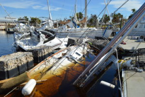 Half submerged sailboat next to dock