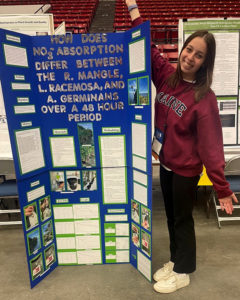 scholarship winner mary reed stands next to her research poster at the state science and engineering fair fair